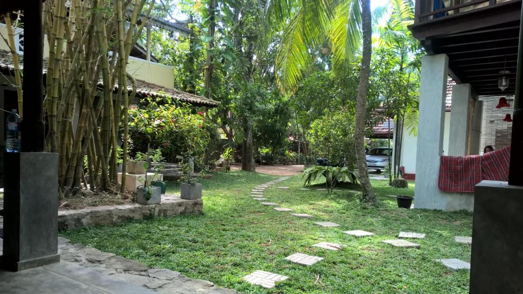 a garden next to a house with a walkway at Silva Rest in Unawatuna