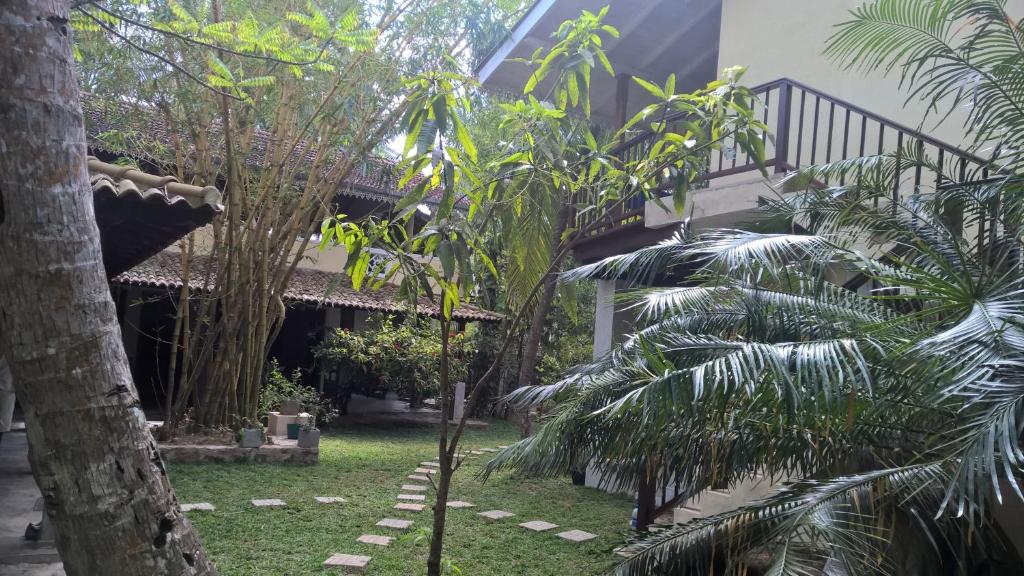 a garden with palm trees and a staircase at Silva Rest in Unawatuna