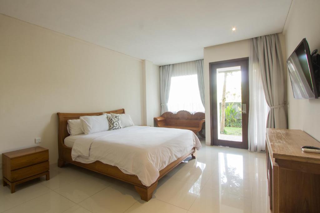Un dormitorio con una cama y un escritorio y una ventana. en Soraya Apartment Seminyak, en Seminyak