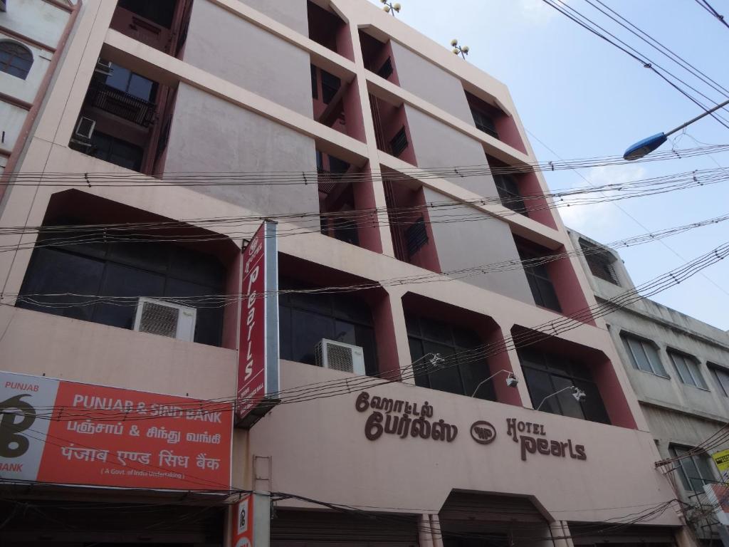 a building with a sign on the side of it at Hotel Pearls in Madurai