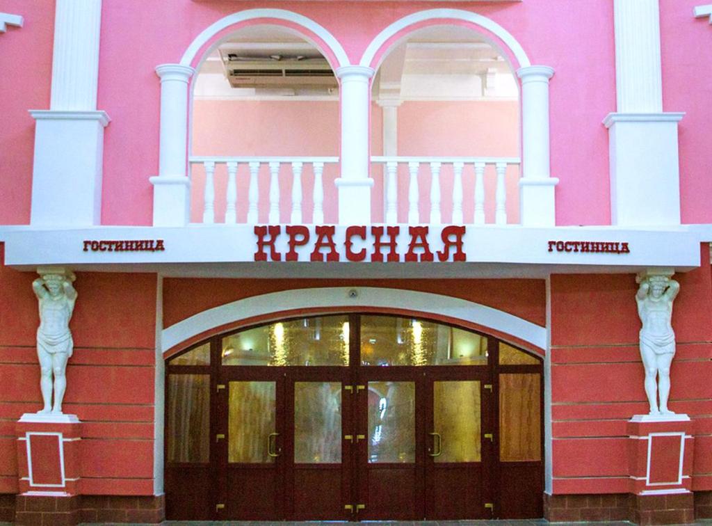 a pink building with a sign on the front of it at Gostinitsa Krasnaya in Blagoveshchensk