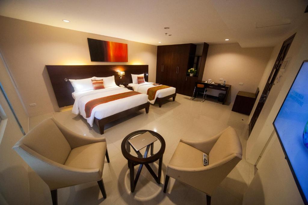 a large hotel room with two beds and chairs at NS Royal Hotel in Cebu City