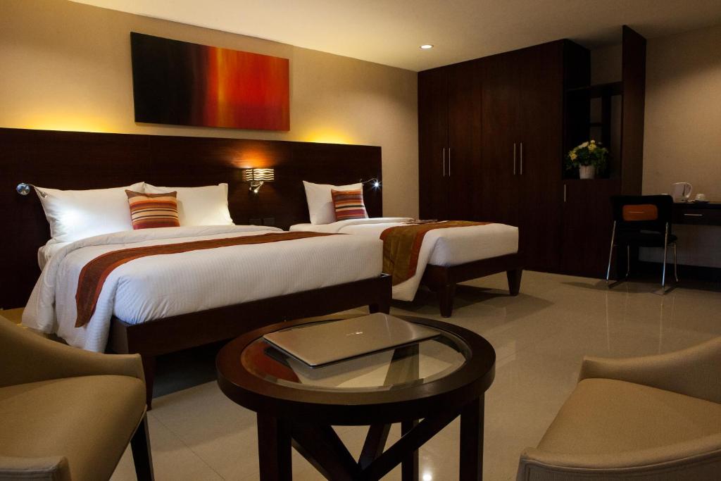 a hotel room with two beds and a table at NS Royal Hotel in Cebu City