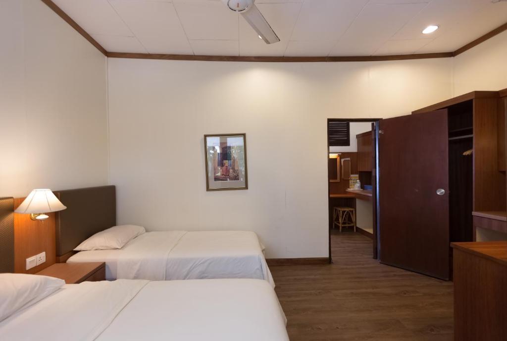 プルフンティアン島にあるツナ ベイ アイランド リゾートのベッド2台とデスクが備わるホテルルームです。