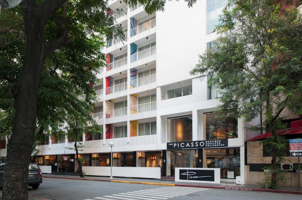 a tall white building with a store in front of it at The Picasso Boutique Serviced Residences Managed by HII in Manila