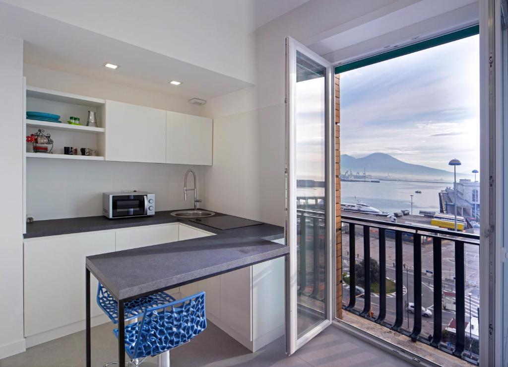 uma cozinha com uma varanda com vista para o oceano em Relais Castel Nuovo em Nápoles