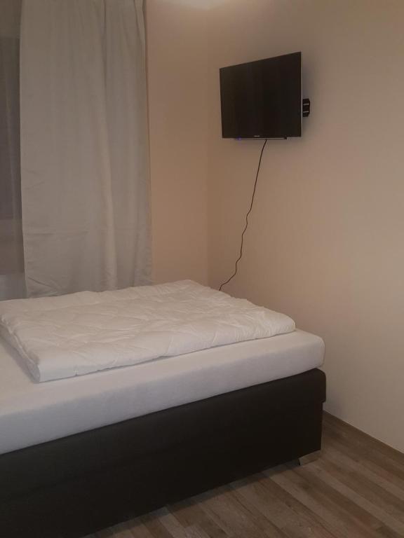 a bed with a tv on the corner of a room at Hotel-Residenz Oberurseler Hof in Oberursel