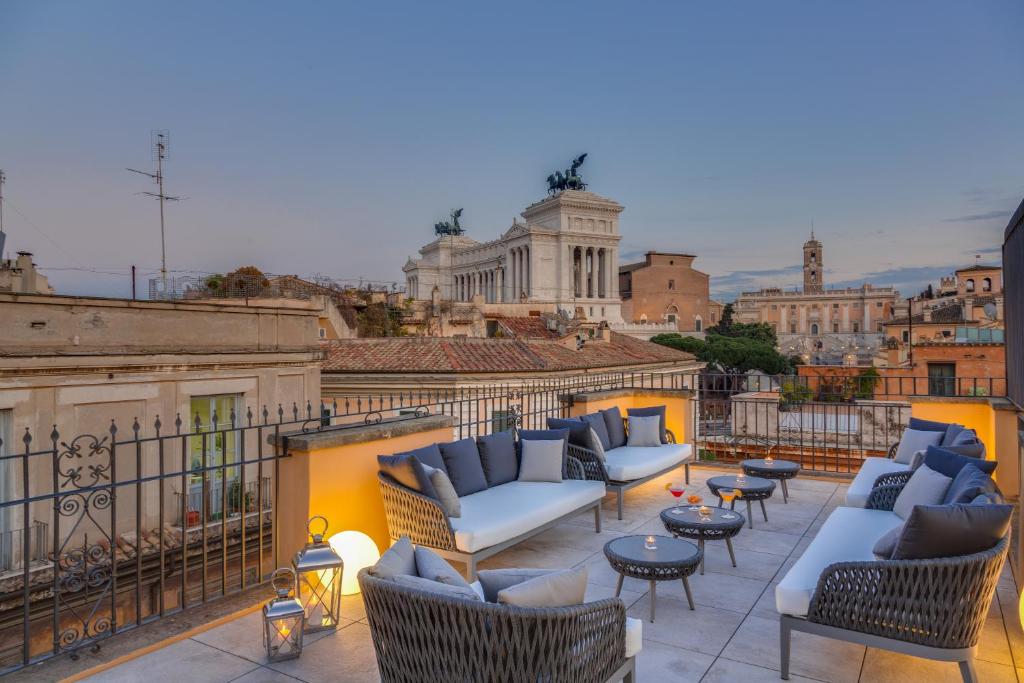 eine Terrasse mit Sofas und Tischen auf dem Balkon in der Unterkunft Otivm Hotel in Rom