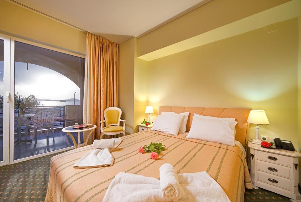 Habitación de hotel con cama grande y balcón. en Angelika Pallas Hotel en Igoumenitsa