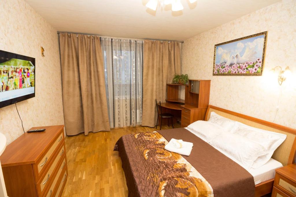 モスクワにある2-х комнатные апартаменты Ельのベッドとテレビが備わるホテルルームです。