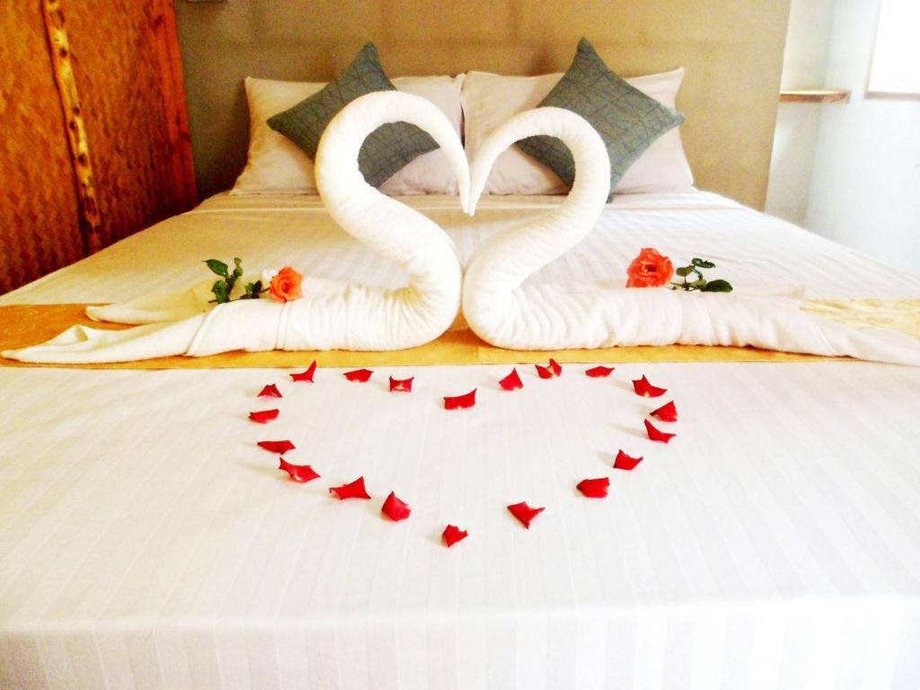 two white swans forming a heart on a bed at Rimsuan House in Ko Lanta