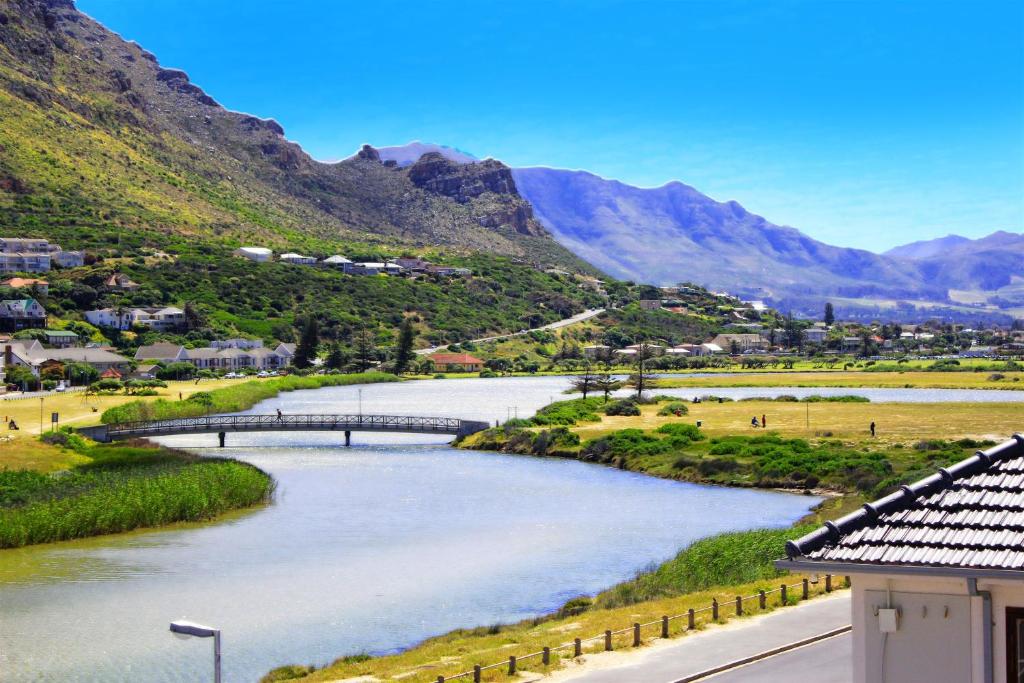 a bridge over a river with mountains in the background at The Muize in Muizenberg