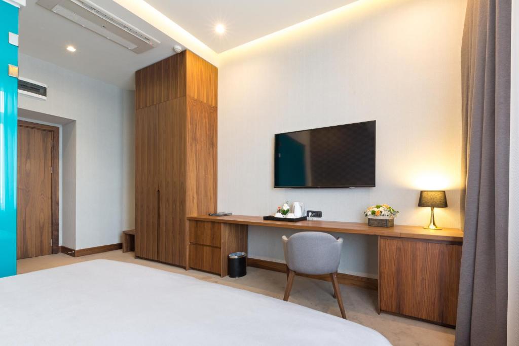 a hotel room with a desk and a tv at Five Points Square - City Center in Belgrade