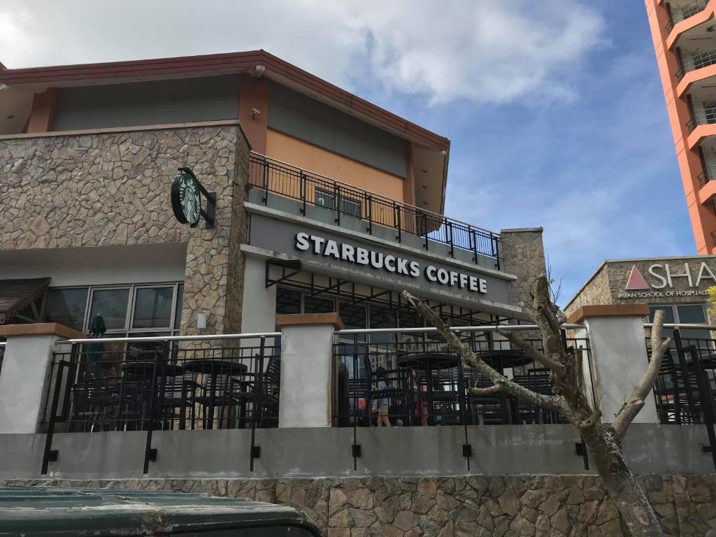 a building with a sign for a starbucks coffee at JJ Suites Tagaytay @ Wind Residences in Tagaytay