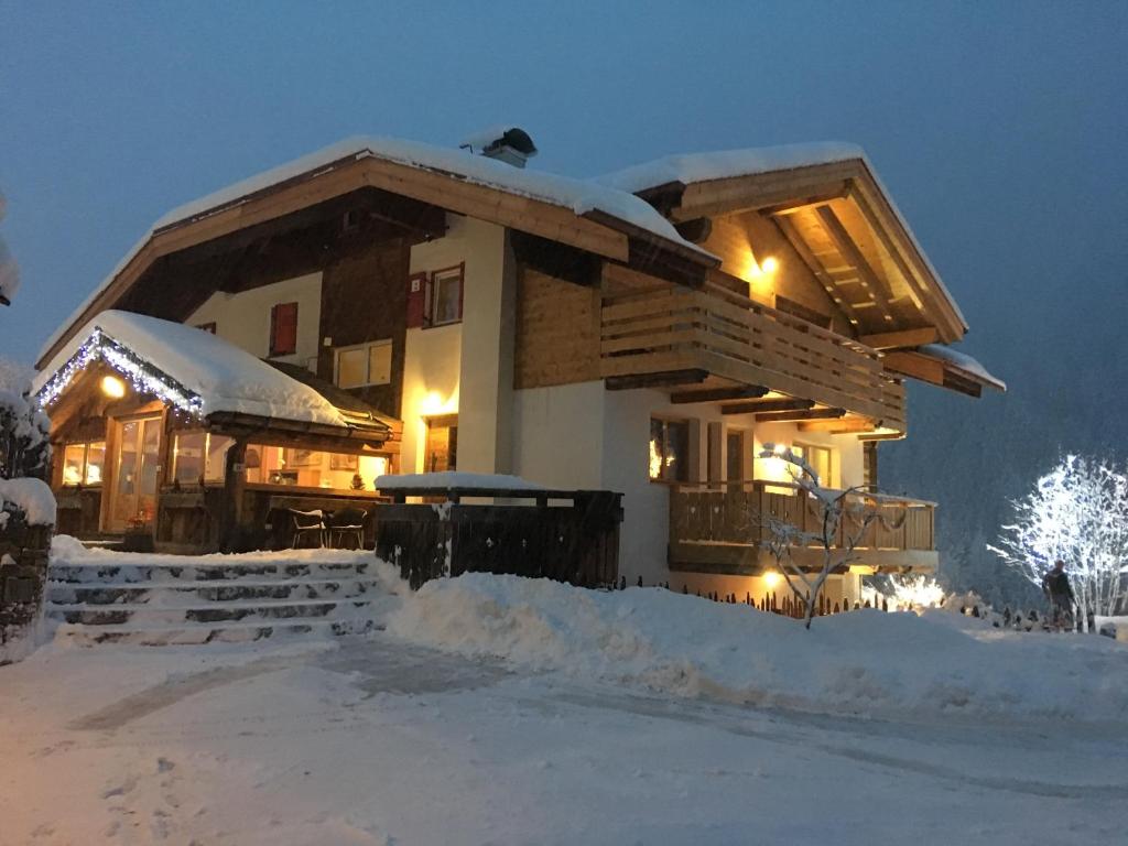 una casa cubierta de nieve por la noche en Appartamenti Chalet Orchidea en Canazei