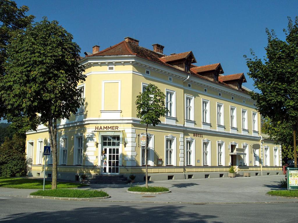 um grande edifício amarelo com um telhado vermelho em Hotel Hammer em Weiz