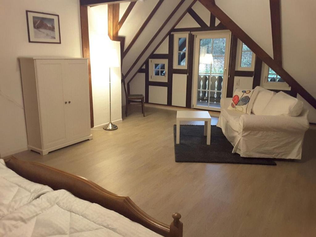 Pokój na poddaszu z łóżkiem i kanapą w obiekcie Berghof Schmitte w mieście Winterberg