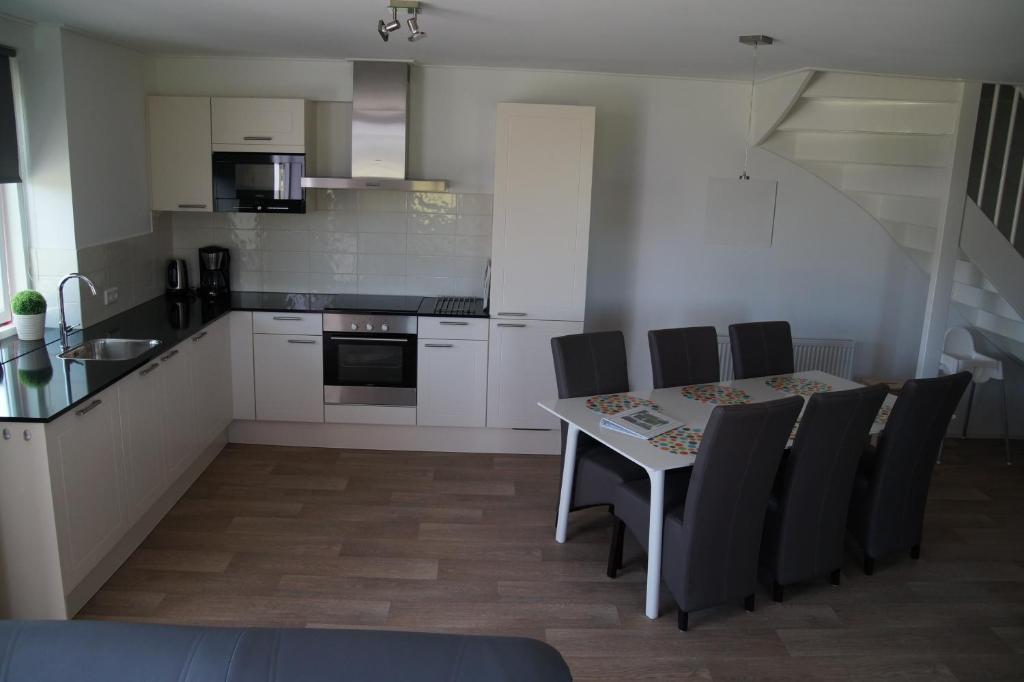 eine Küche mit einem Tisch und Stühlen im Zimmer in der Unterkunft Vakantiehuizen Hofstede Elzenoord in Vrouwenpolder