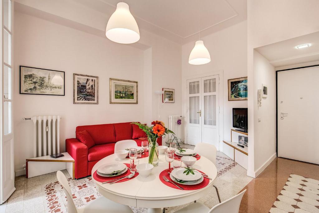 sala de estar con mesa y sofá rojo en La casa di Nonna Pina en Roma