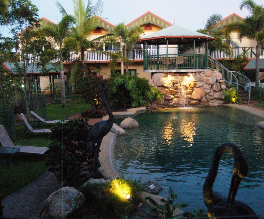 Tinaroo的住宿－迪納魯湖度假酒店，一座有天鹅的房子前的游泳池