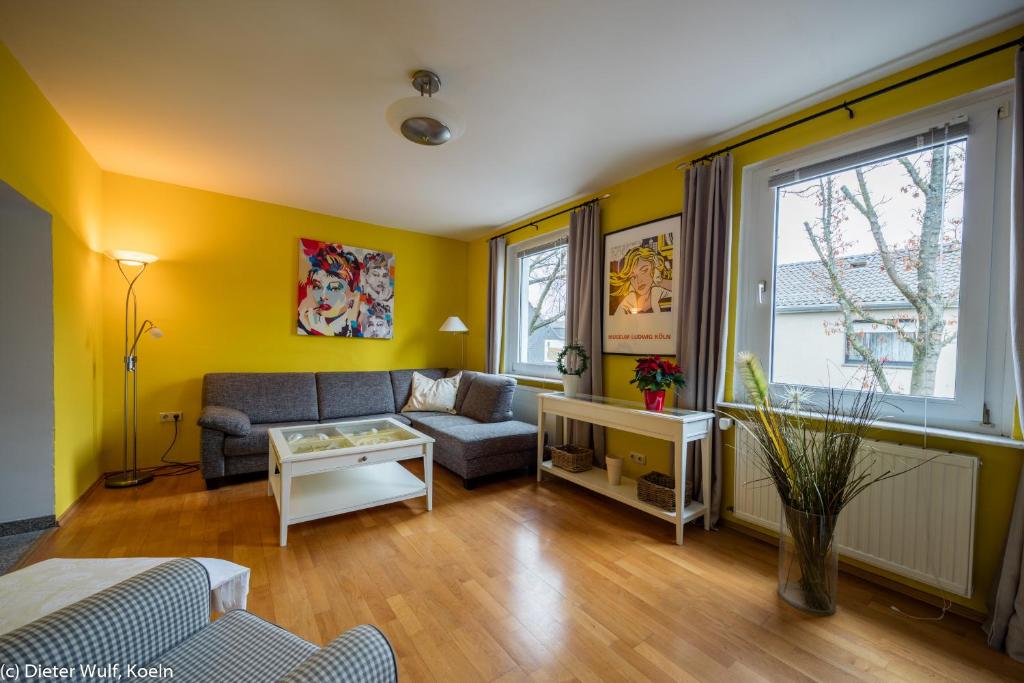 ein Wohnzimmer mit gelben Wänden und einem Sofa in der Unterkunft Hürth-Efferen1 in Hürth