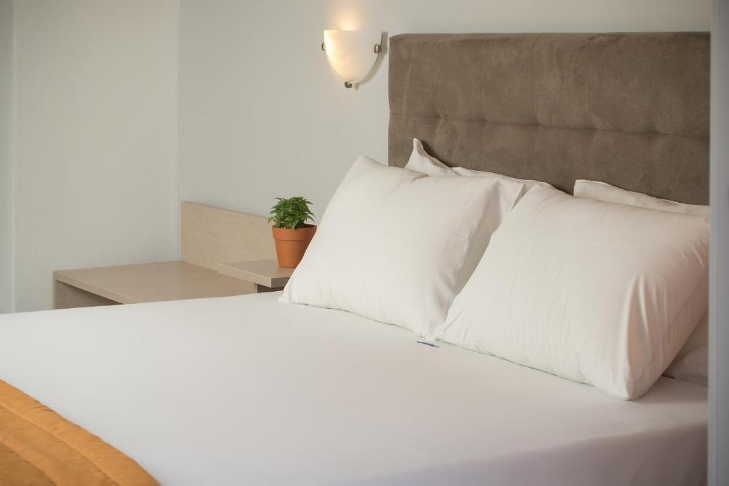 A bed or beds in a room at Coral Blue Beach Hotel Gerakini