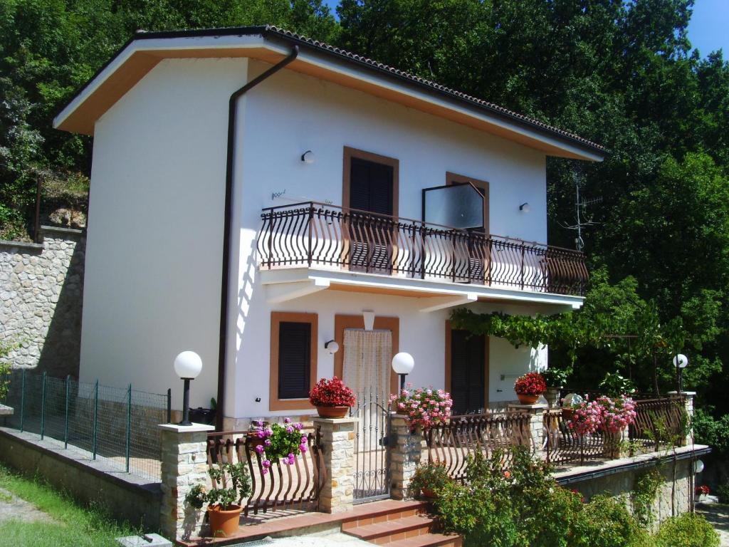 een klein wit huis met een balkon en bloemen bij Casa Lieta in Subiaco