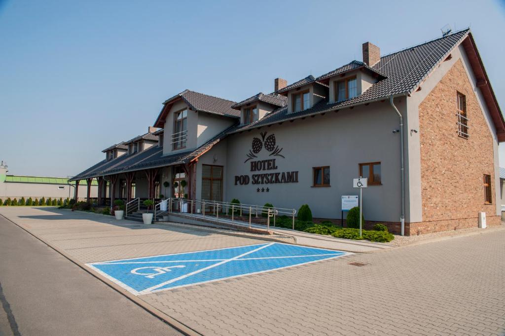 un bâtiment avec un panneau pour personnes à mobilité réduite dans la rue dans l'établissement Hotel Pod Szyszkami, à Koźmin