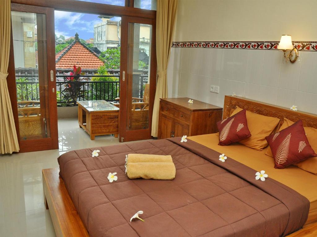 Un dormitorio con una cama grande con flores. en Mira Family Homestay, en Ubud