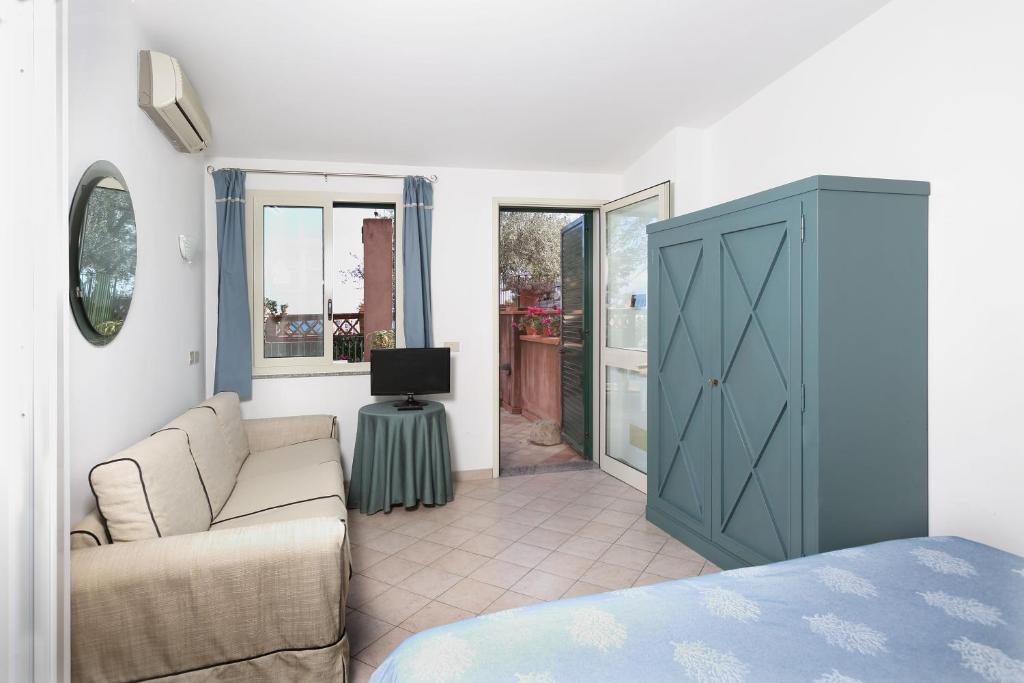a living room with a couch and a tv at Hotel Villino Gallodoro in Taormina