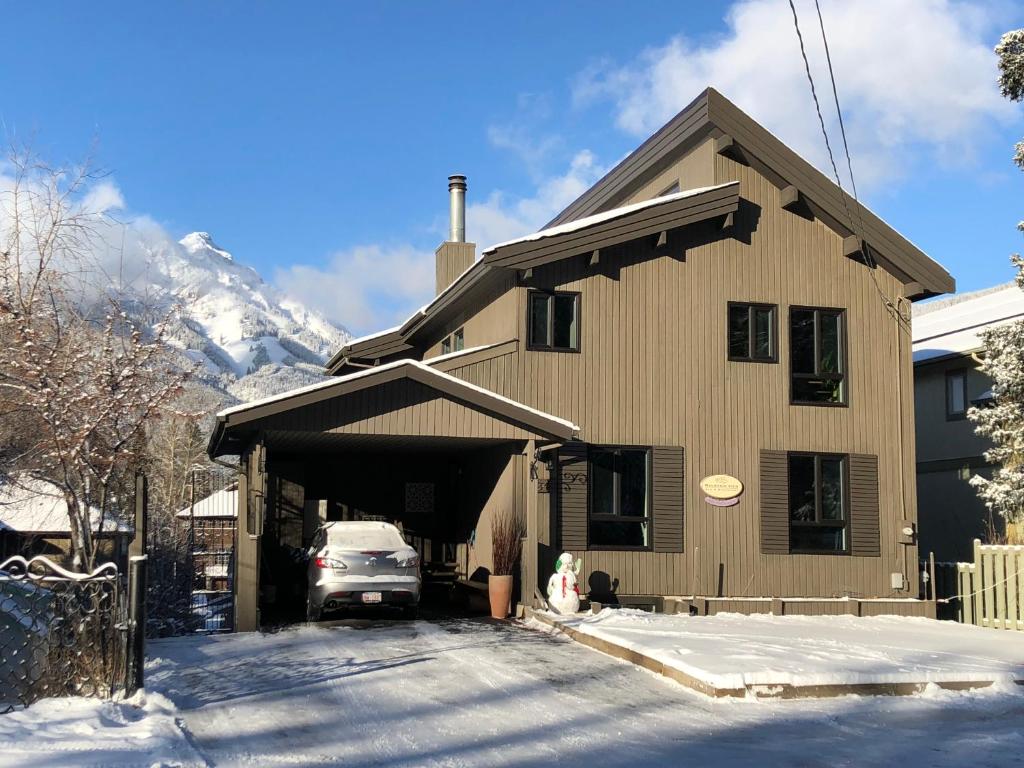 a house with a car parked in front of it in the snow at Mountain View Bed & Breakfast in Banff
