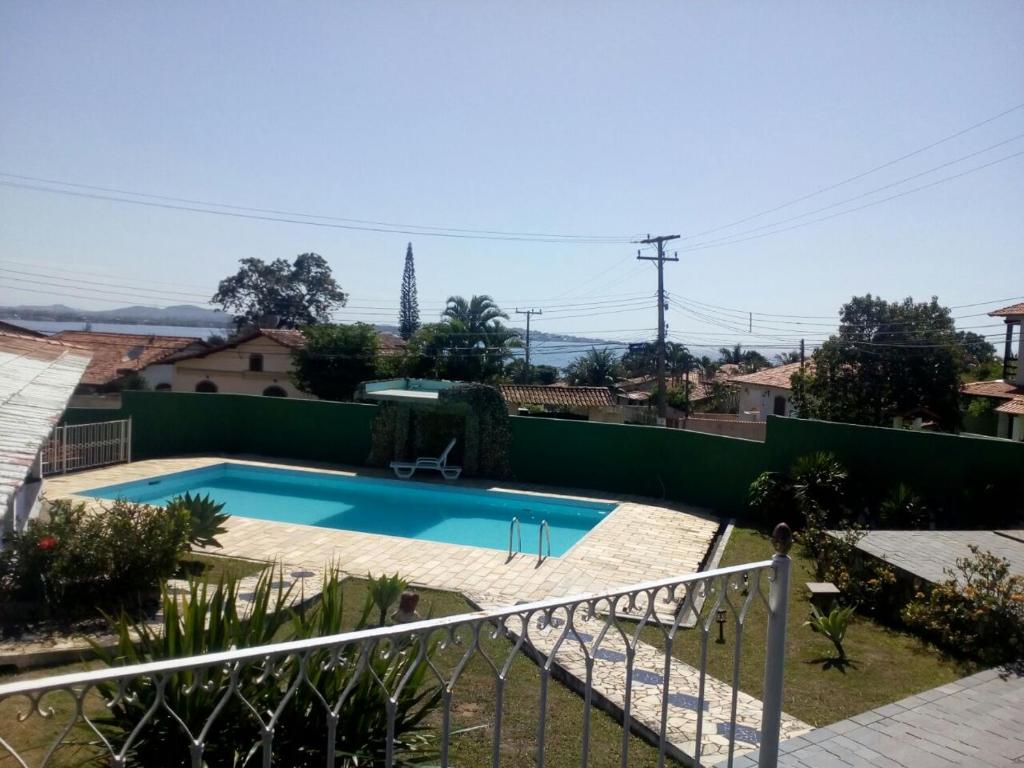 a swimming pool in a yard with a fence at Pousada Tourne Bride in Araruama