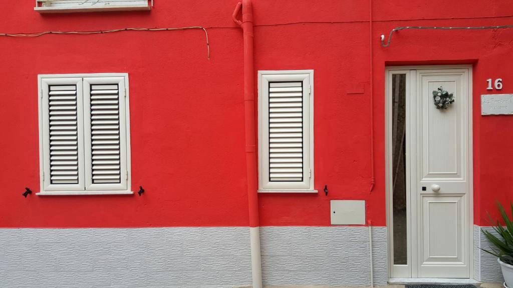 Giardina Gallotti的住宿－La Finestrella，红色的建筑,有白色的窗户和红色的墙壁