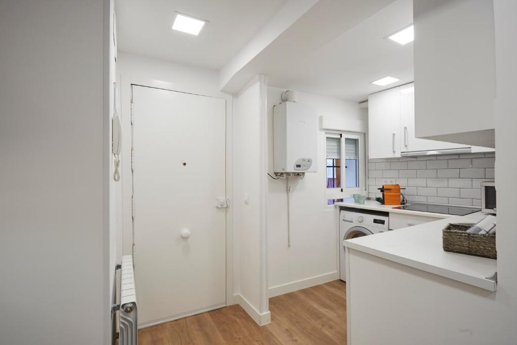 a kitchen with white cabinets and a white counter top at LEEWAYS APARTMENT in SAN LORENZO in Madrid