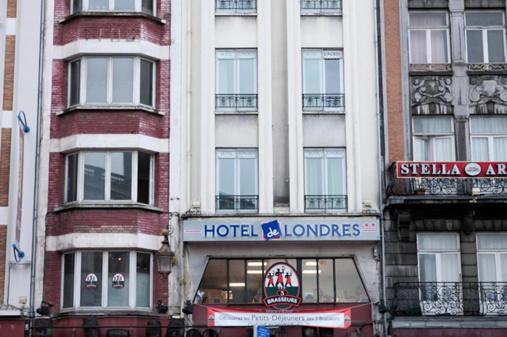 un bâtiment avec un panneau d'hôtels devant lui dans l'établissement Hotel De Londres, à Lille