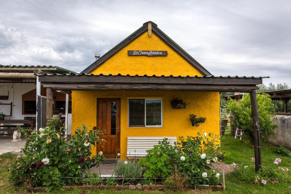 Una pequeña casa amarilla con un cartel. en La Chacra Holandesa, en Atlántida