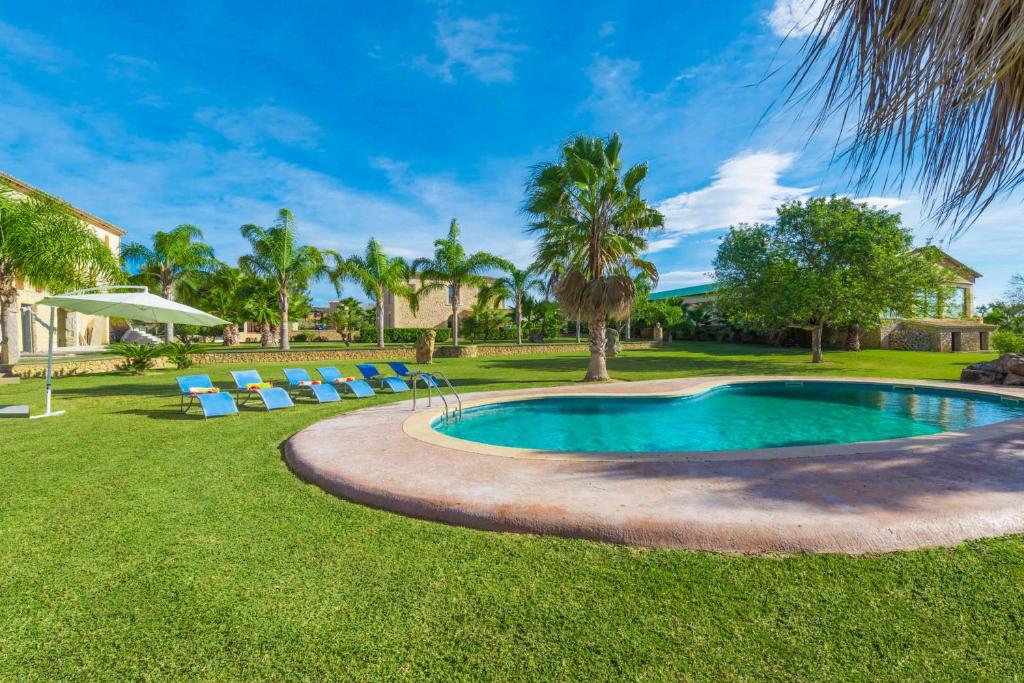 einen Pool im Garten mit Stühlen und Bäumen in der Unterkunft Son Perot in Maria de la Salut