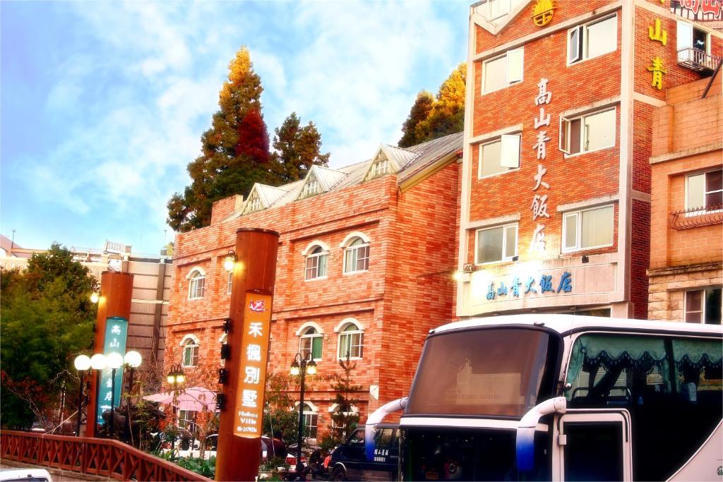 un camión estacionado frente a un edificio de ladrillo en Gau Shan Ching Hotel, en Zhongzheng