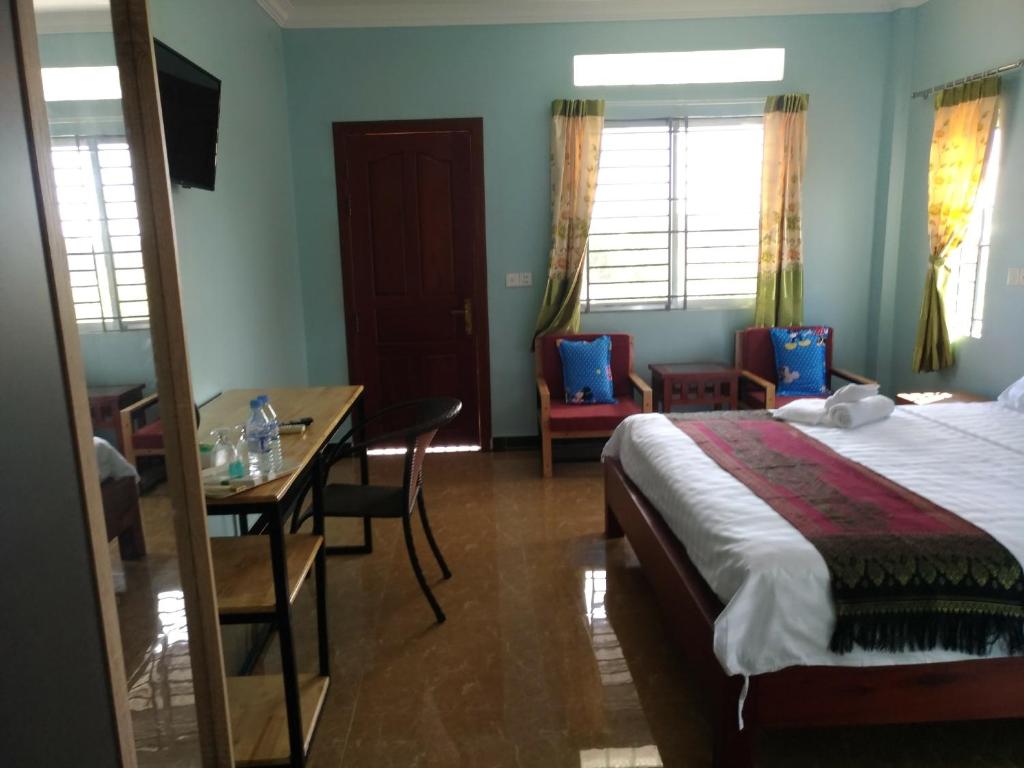 a hotel room with a bed and a table and chairs at Siem Reap home in Siem Reap