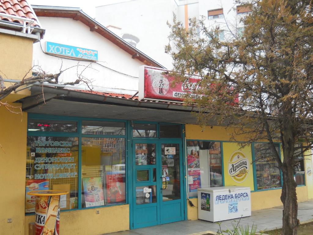 una tienda con una puerta azul y un árbol delante en Hotel Orient, en Blagoevgrad