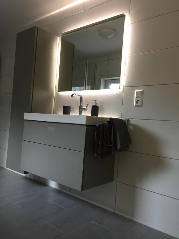 ein Badezimmer mit Waschbecken und Spiegel in der Unterkunft Ferienhaus Kluntje in Emden