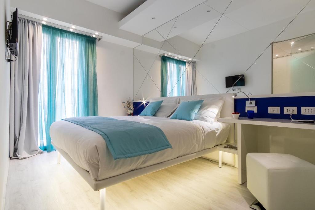 une chambre avec un grand lit avec un miroir dans l'établissement Hotel Nuovo Giardino, à Rimini
