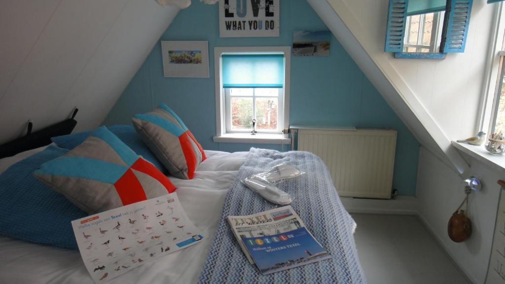 ein kleines Schlafzimmer mit einem Bett mit einer Treppe in der Unterkunft B&B kamers en meer Het Spookhuis in Den Hoorn