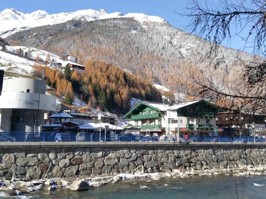 a building next to a river with a mountain at Heiners in Sölden