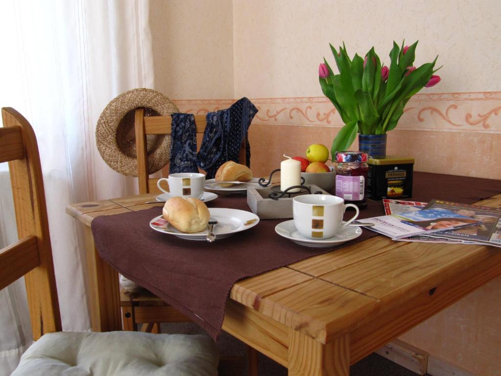 een eettafel met eten en koffiekopjes erop bij Ferienwohnung Erfurt in Erfurt