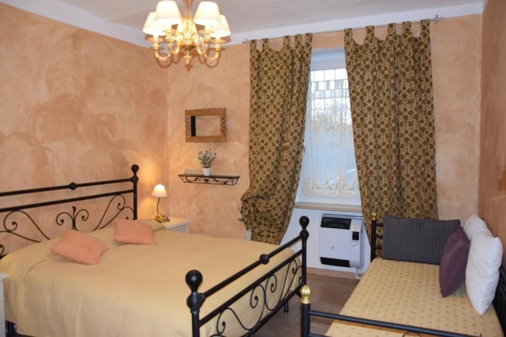 ein Schlafzimmer mit einem Bett, einem Sofa und einem Fenster in der Unterkunft A casa di Gloria in Acqui Terme