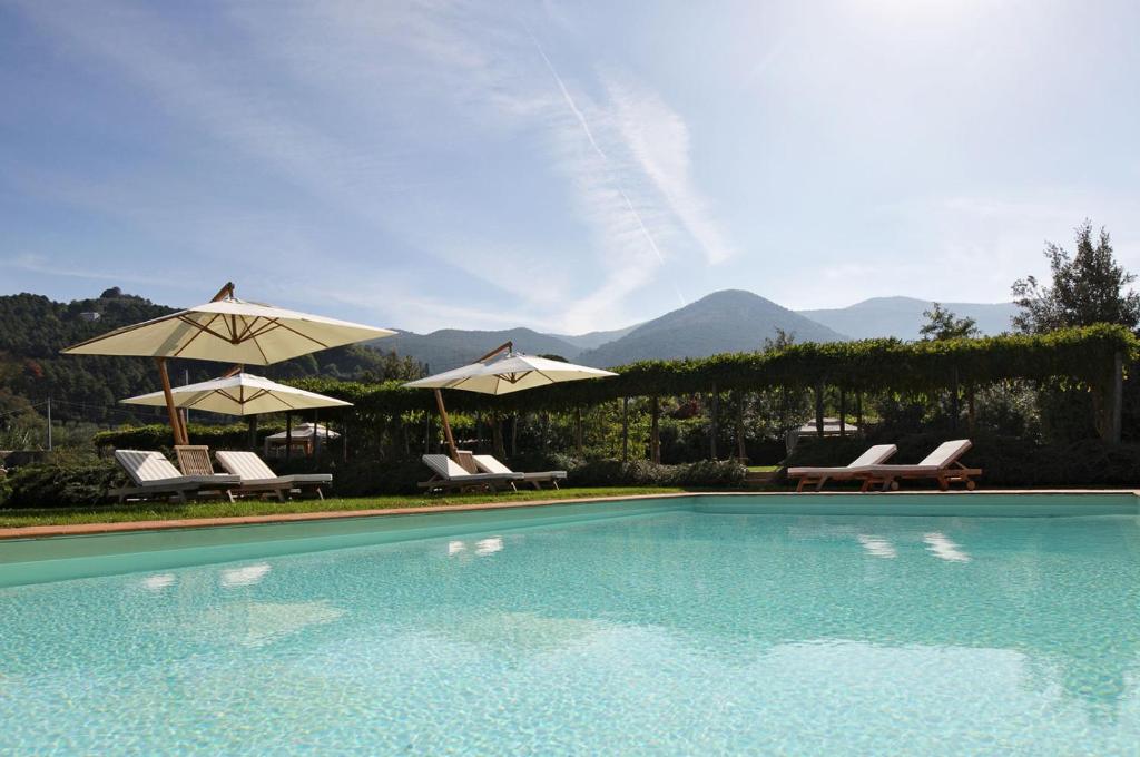 una piscina con due ombrelloni e alcune sedie di ai Santinelli a Lucca