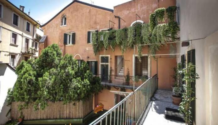 un edificio de apartamentos con un balcón con plantas. en Cortiletto, en Verona