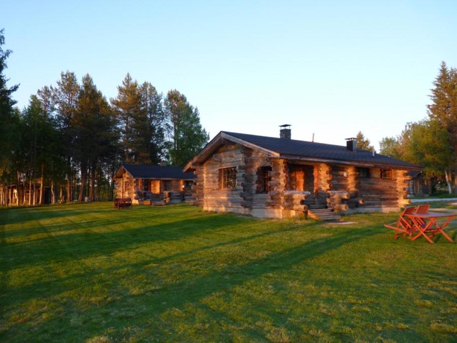 una cabaña de madera en un campo con un gran patio en Karhujärven Kelopirtit, en Karhujarvi