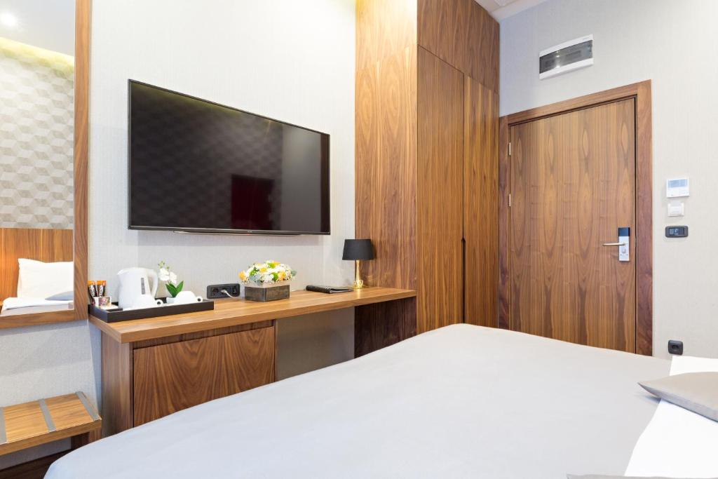 a hotel room with a bed and a flat screen tv at Five Points Square - City Center in Belgrade